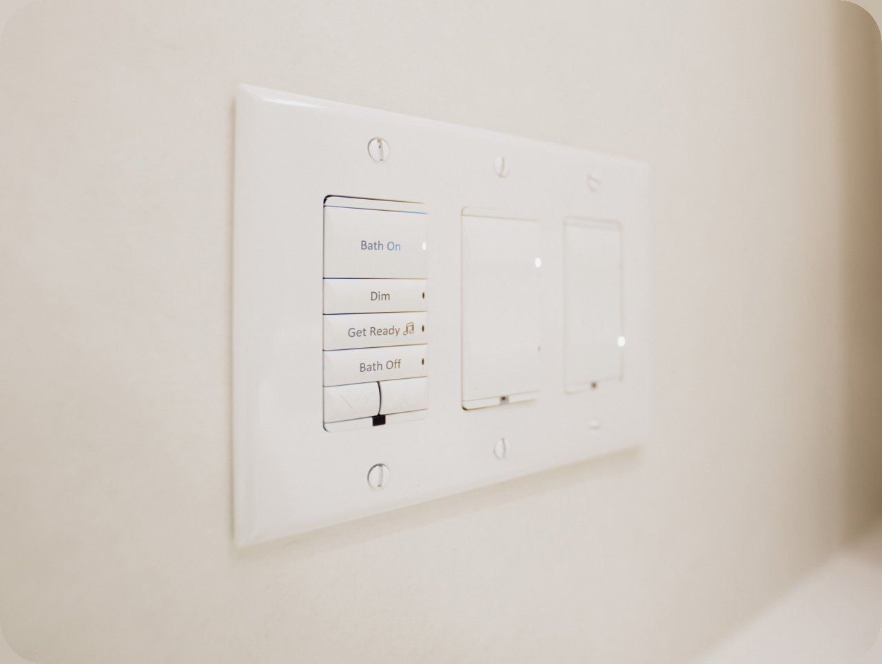 A lighting-control keypad mounted flush on a plaster wall